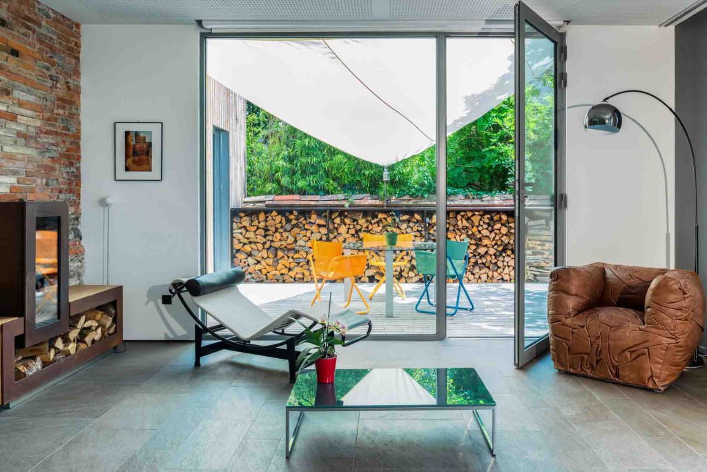 Salon de la maison passive de Seuil architecture, avec son poêle à bois et son bûcher